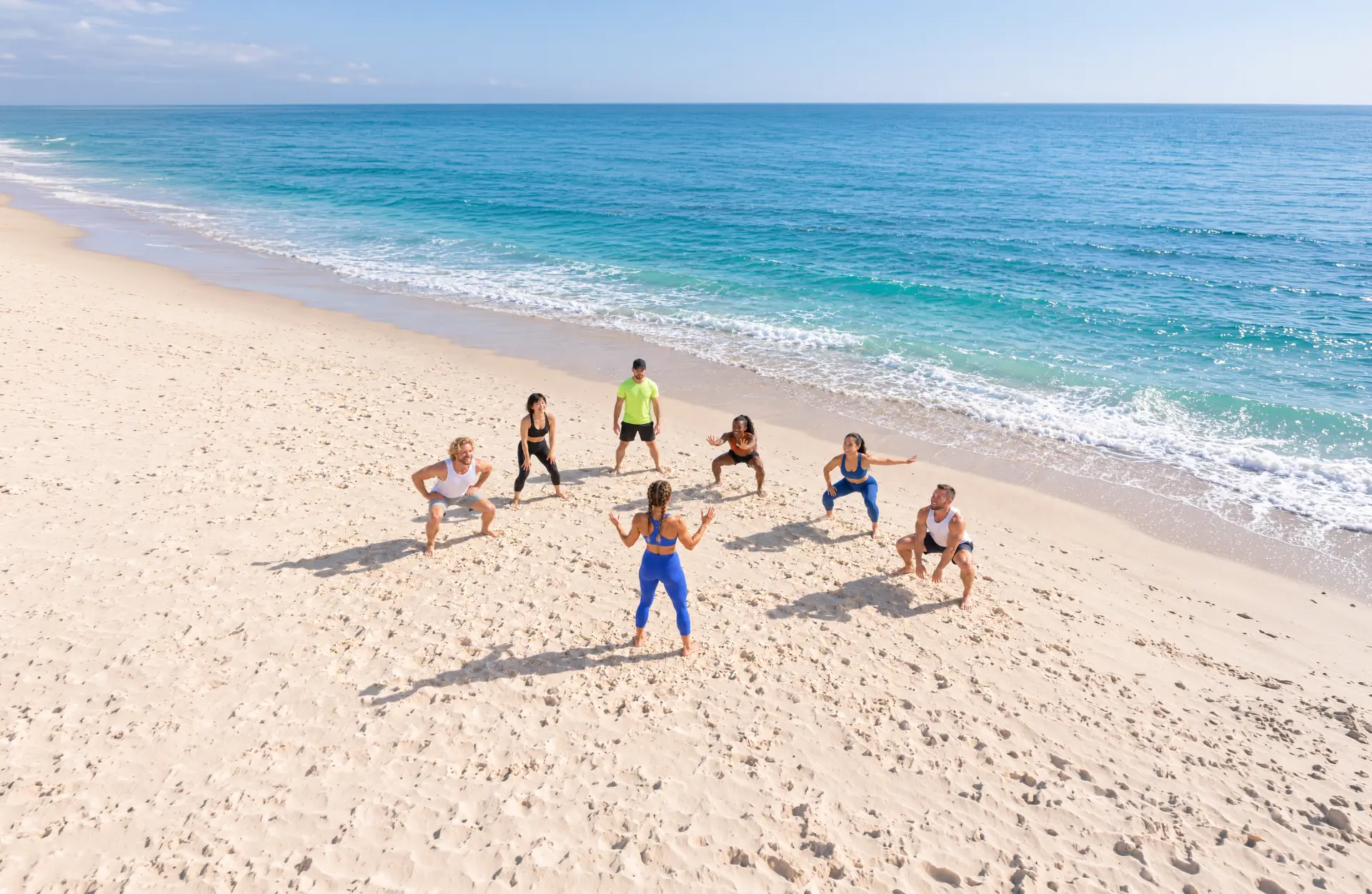 A group of fitness professionals sitting together and chatting on an Australian beach