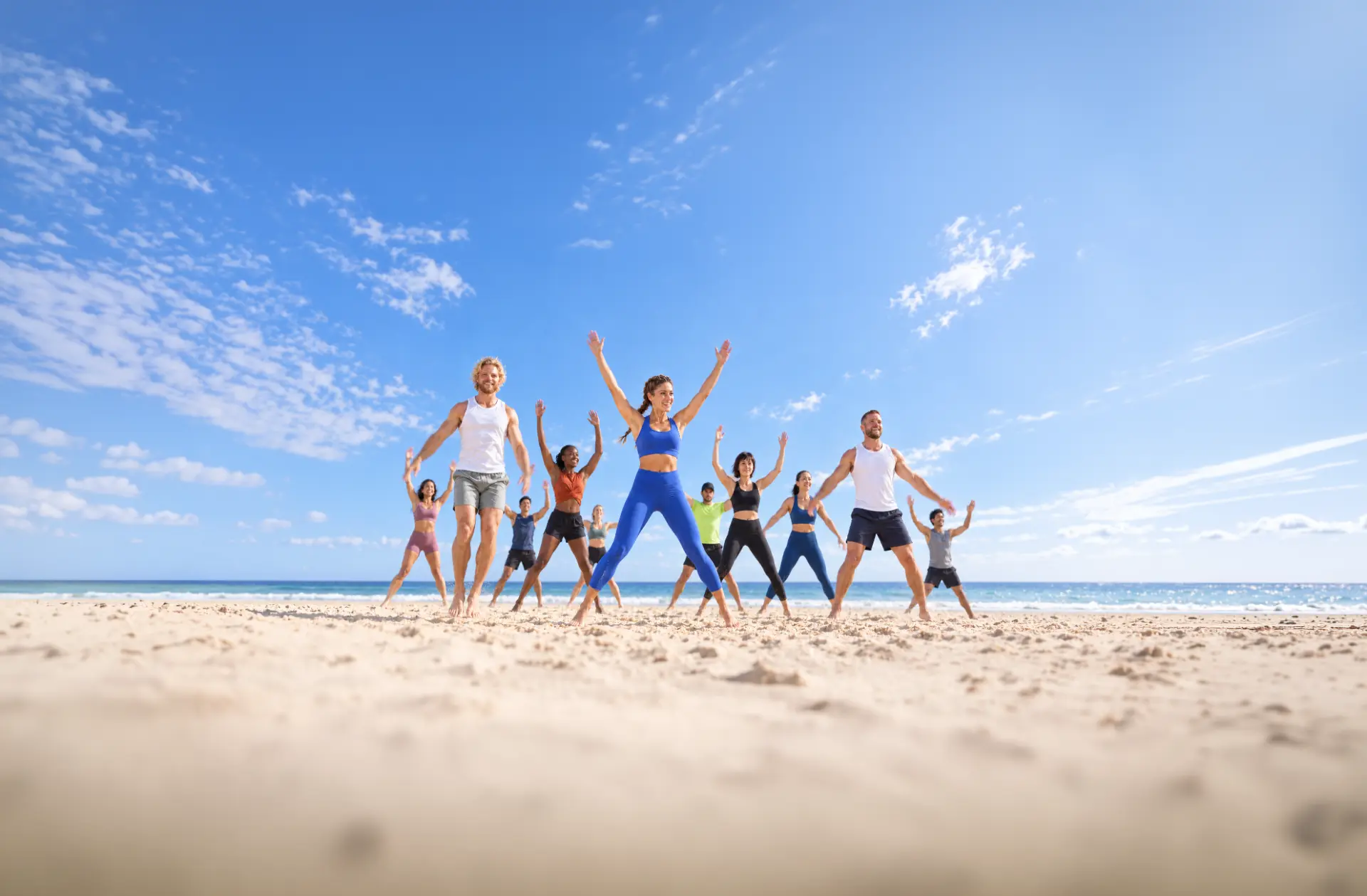 A group of fitness professionals training together on an Australian beach